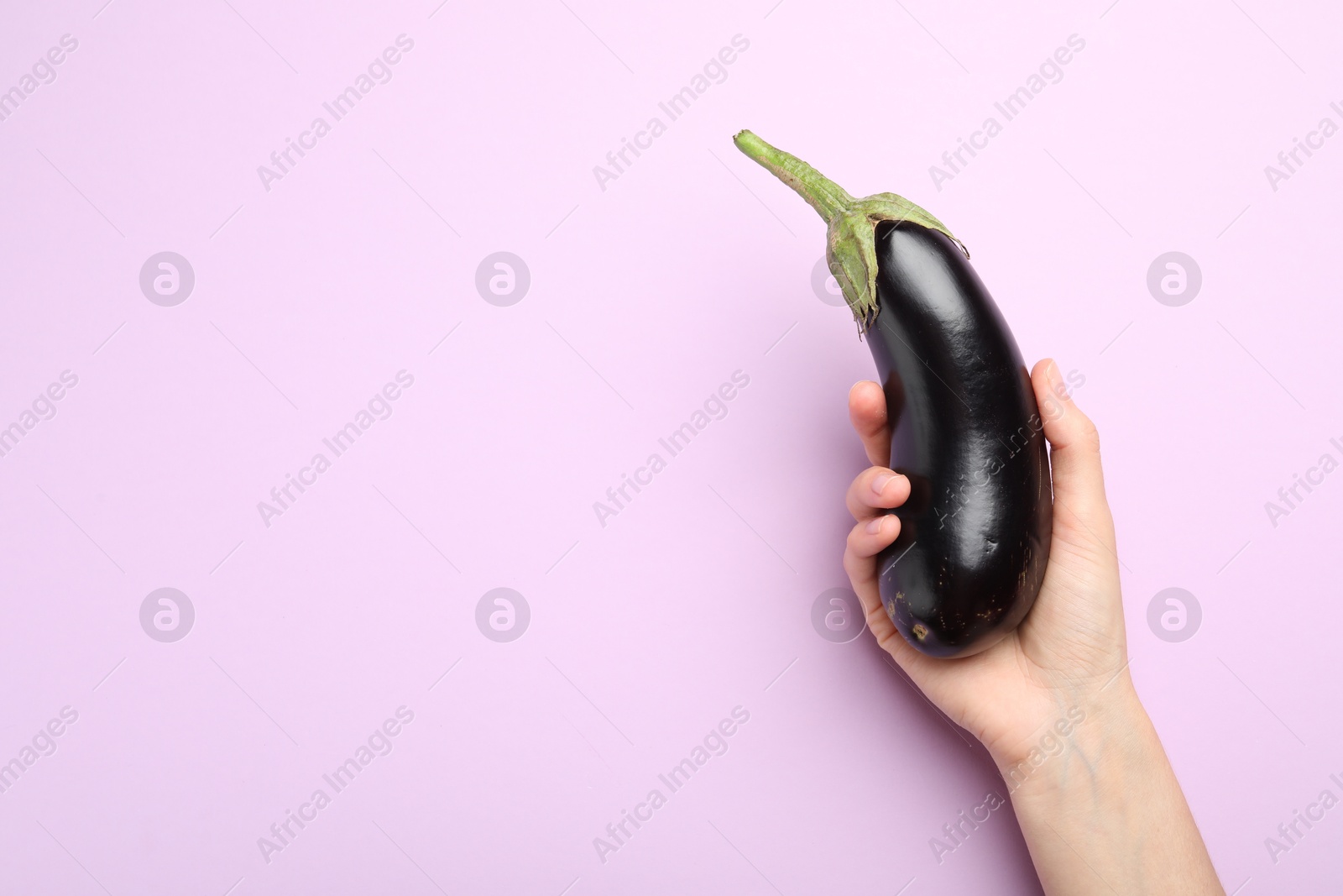 Woman with fresh eggplant on violet background, top view. Space for text Photo of Woman with fresh eggplant on violet background, top view. Space for text