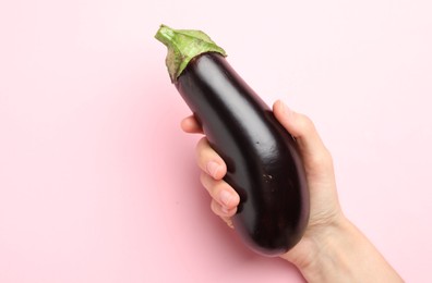 Photo of Woman with fresh eggplant on pink background, top view. Space for text
