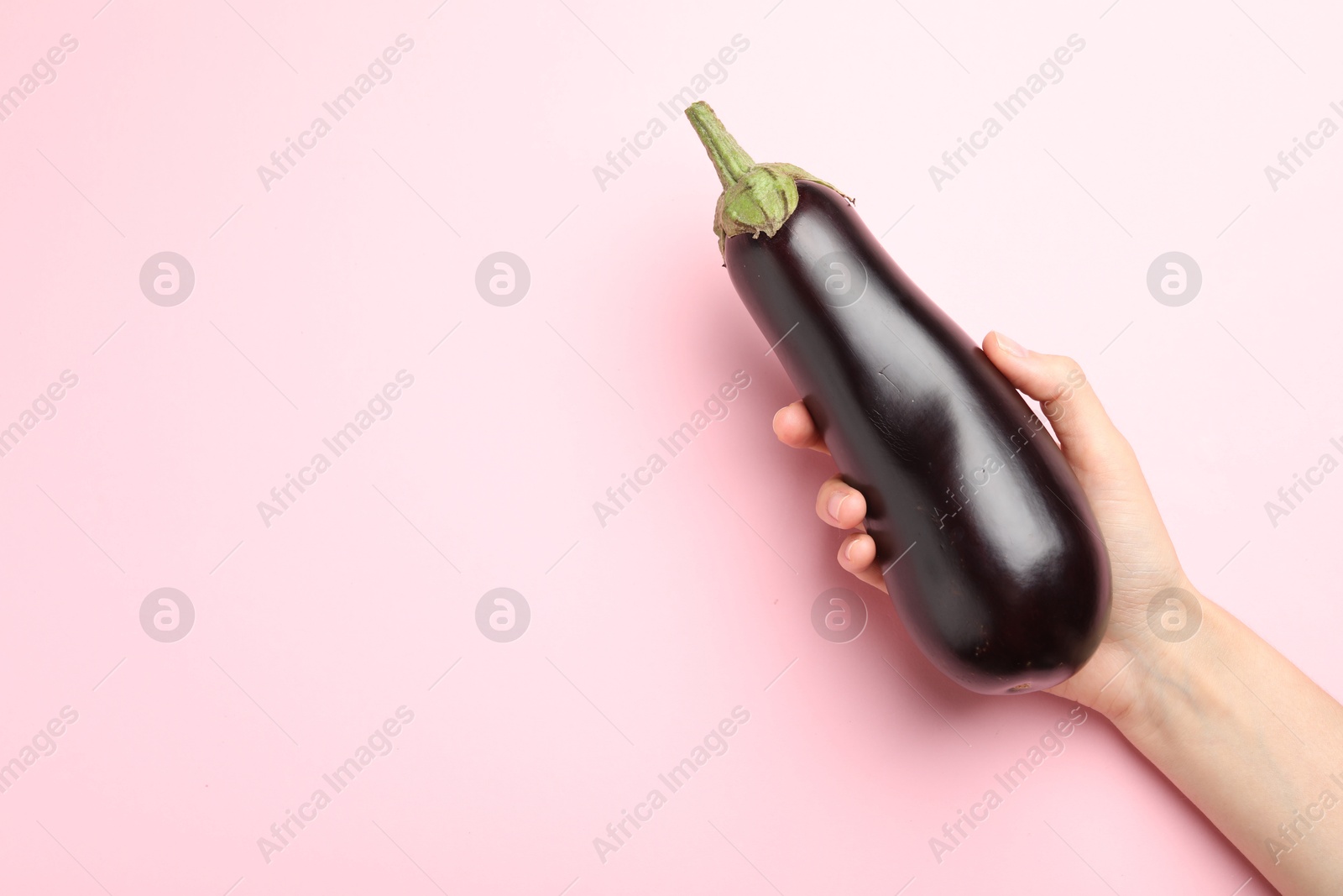 Woman with fresh eggplant on pink background, top view. Space for text Photo of Woman with fresh eggplant on pink background, top view. Space for text