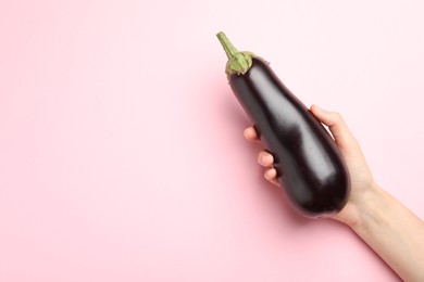 Photo of Woman with fresh eggplant on pink background, top view. Space for text