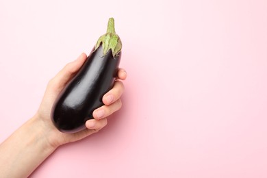 Photo of Woman with fresh eggplant on pink background, top view. Space for text