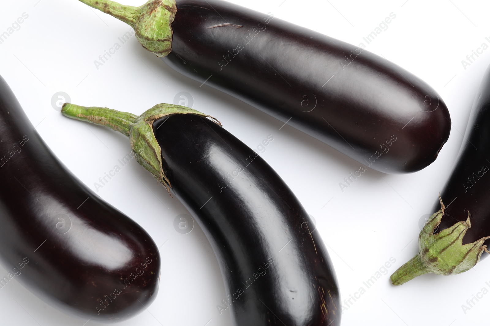 Many fresh eggplants on white background, flat lay Photo of Many fresh eggplants on white background, flat lay