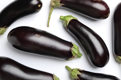 Photo of Many fresh eggplants on white background, flat lay