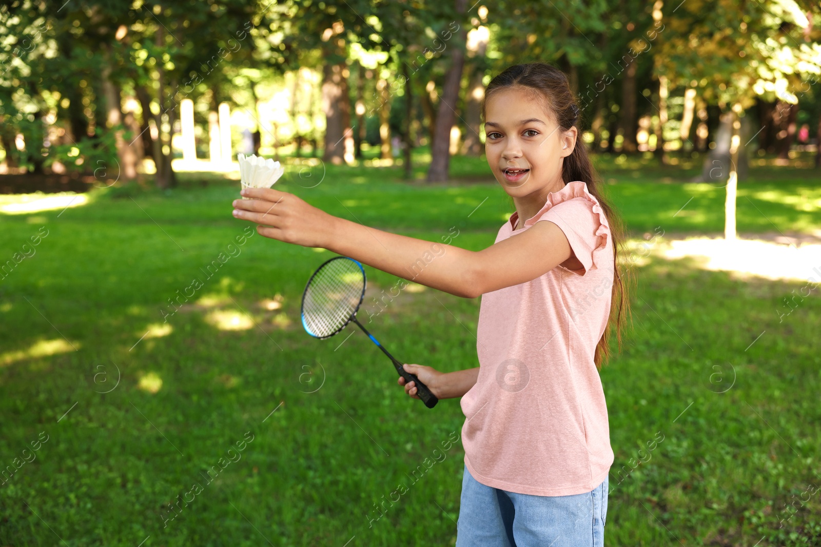 Portrait of smiling little girl with badminton racket and shuttlecock in park Photo of Portrait of smiling little girl with badminton racket and shuttlecock in park