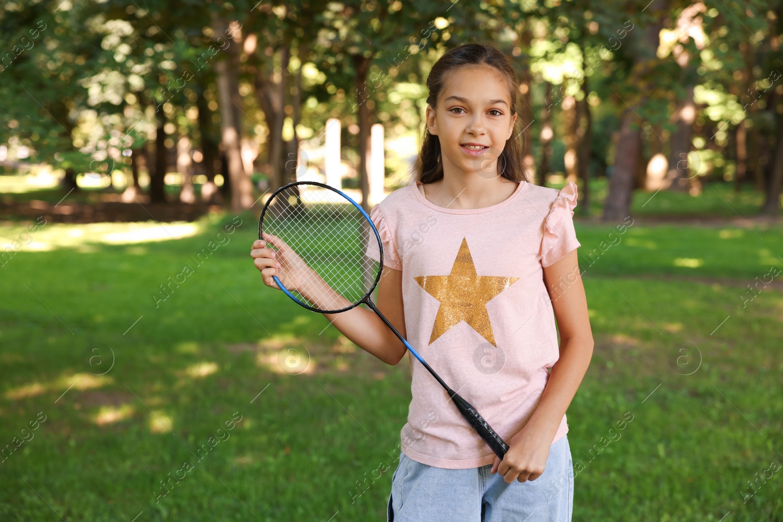 Portrait of smiling little girl with badminton racket in park Photo of Portrait of smiling little girl with badminton racket in park