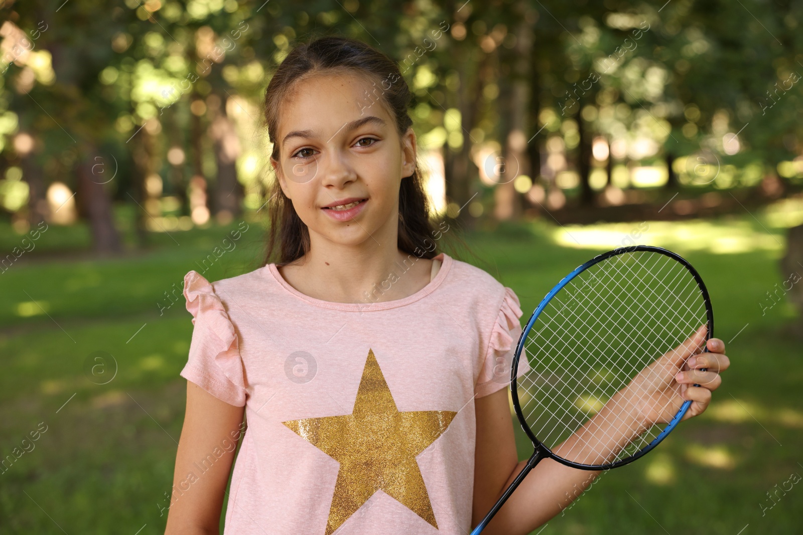 Portrait of smiling little girl with badminton racket in park Photo of Portrait of smiling little girl with badminton racket in park