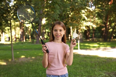 Photo of Portrait of smiling little girl with badminton racket and shuttlecock in park