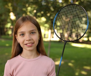 Photo of Portrait of smiling little girl with badminton racket in park