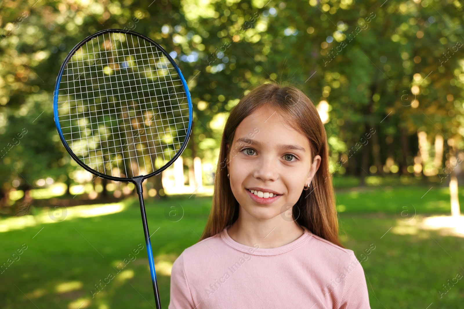 Portrait of smiling little girl with badminton racket in park Photo of Portrait of smiling little girl with badminton racket in park