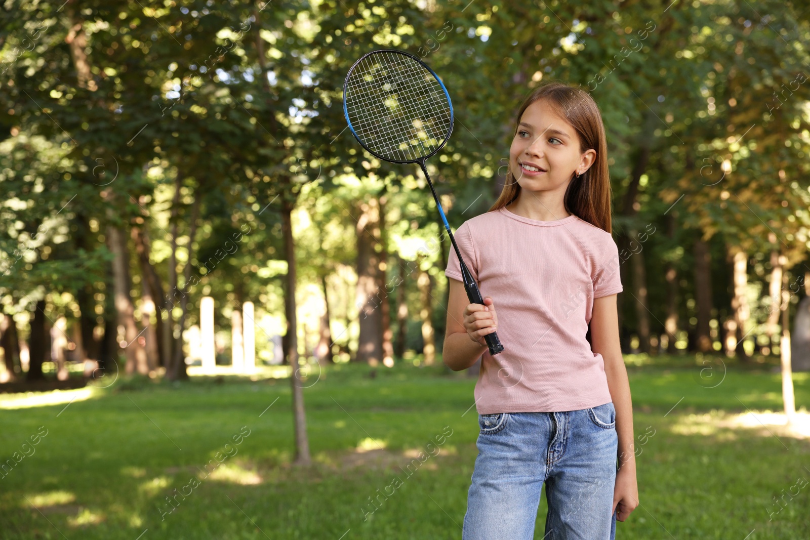 Smiling little girl with badminton racket in park. Space for text Photo of Smiling little girl with badminton racket in park. Space for text