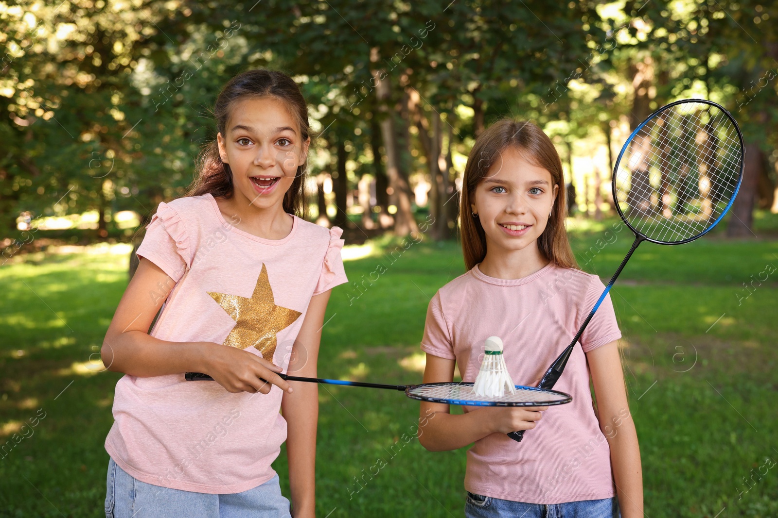 Portrait of smiling little girls with badminton rackets and shuttlecock in park Photo of Portrait of smiling little girls with badminton rackets and shuttlecock in park