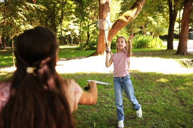 Photo of Cute little girls playing badminton in park