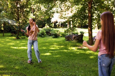 Photo of Cute little girls playing badminton in park