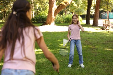 Photo of Cute little girls playing badminton in park