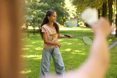 Photo of Cute little girls playing badminton in park, closeup