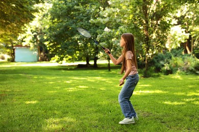 Photo of Cute little girl playing badminton in park