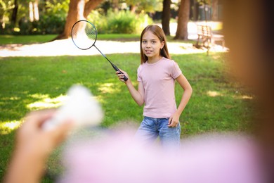 Photo of Cute little girls playing badminton in park, closeup