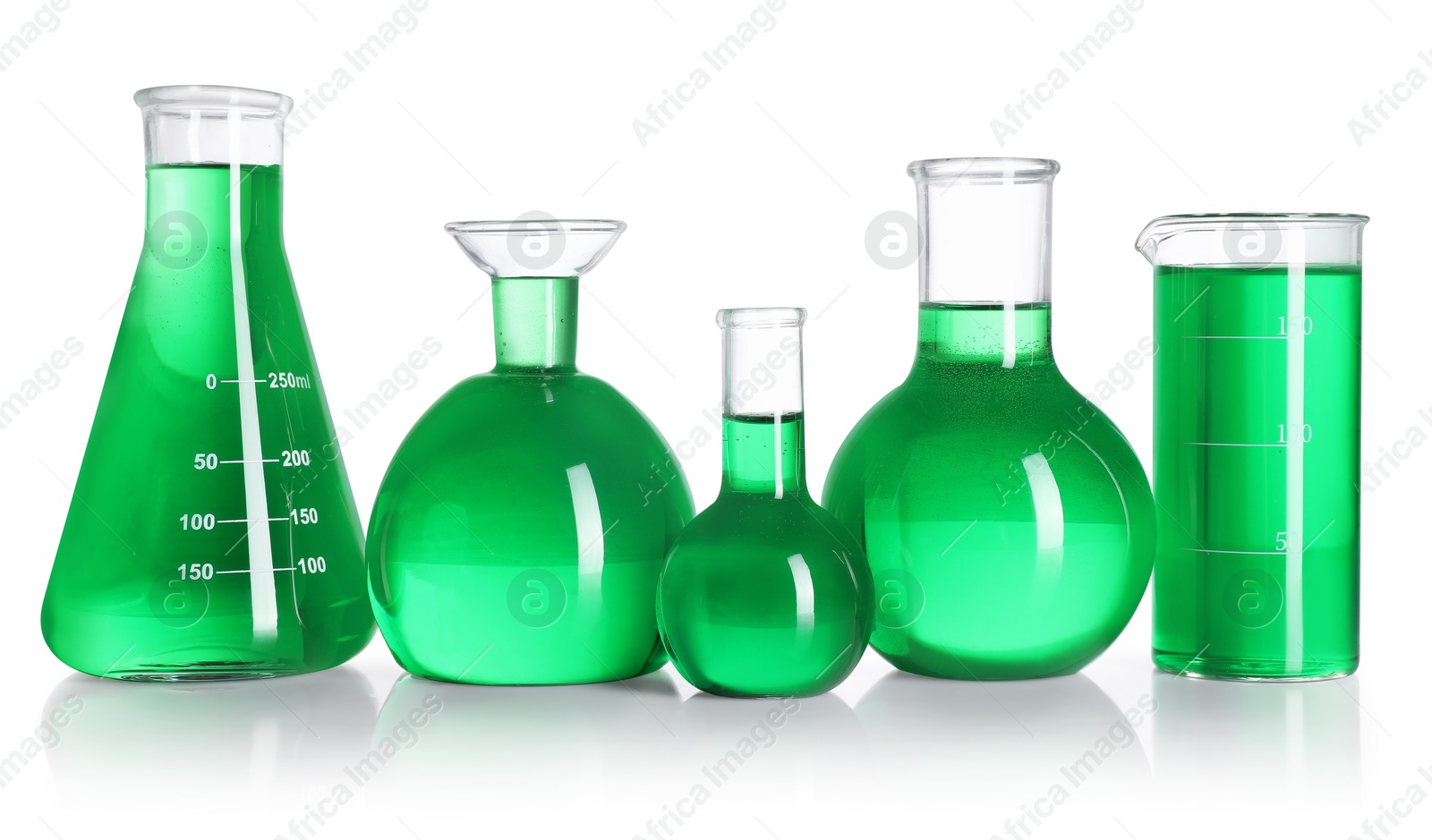 Different laboratory glassware with green liquid on mirror surface isolated on white Photo of Different laboratory glassware with green liquid on mirror surface isolated on white