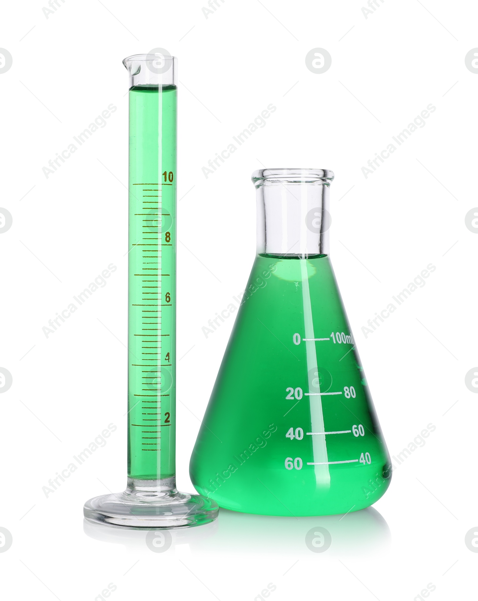 Photo of Laboratory glassware with green liquid on mirror surface isolated on white