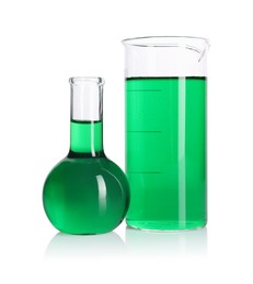Photo of Flask and beaker with green liquid on mirror surface isolated on white