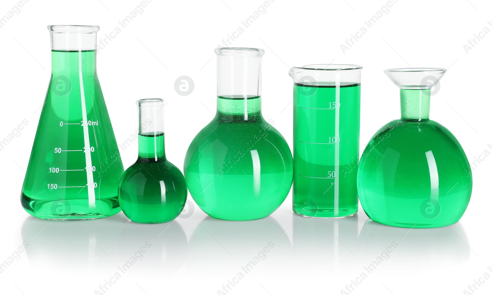 Photo of Different laboratory glassware with green liquid on mirror surface isolated on white