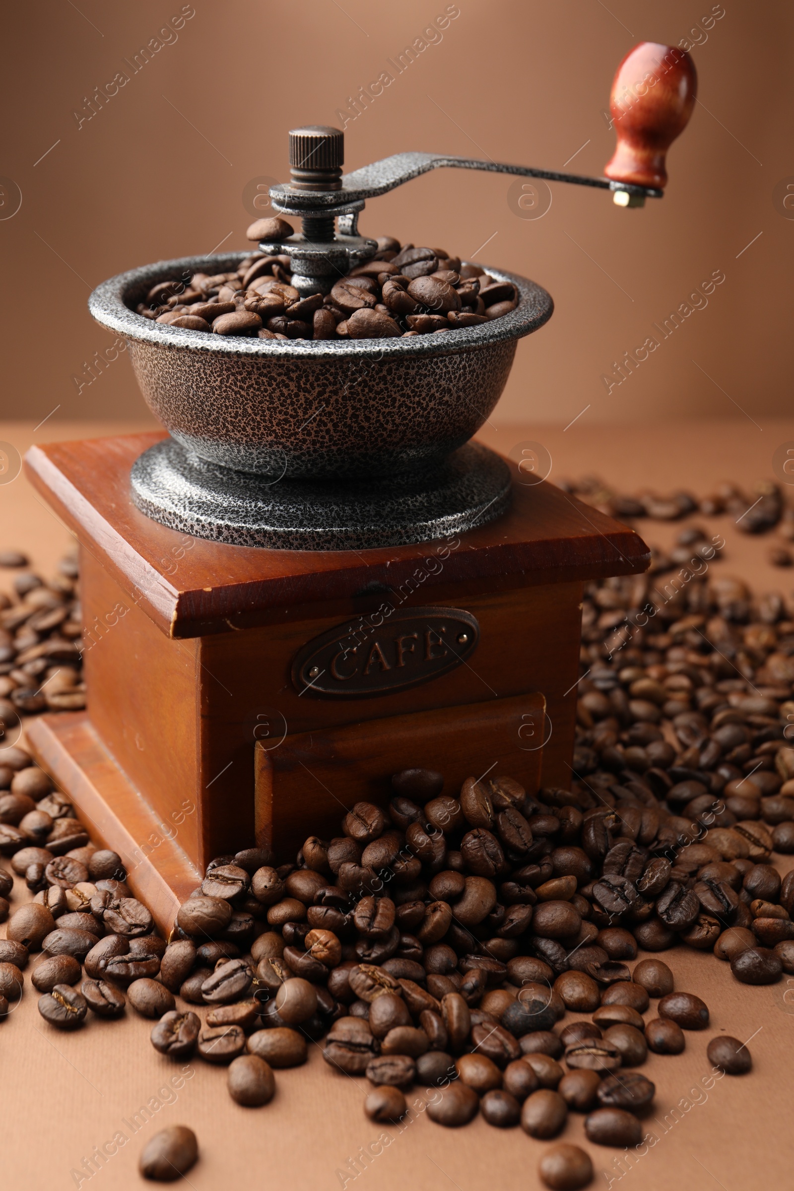 Coffee grinder and beans on brown background, closeup Photo of Coffee grinder and beans on brown background, closeup