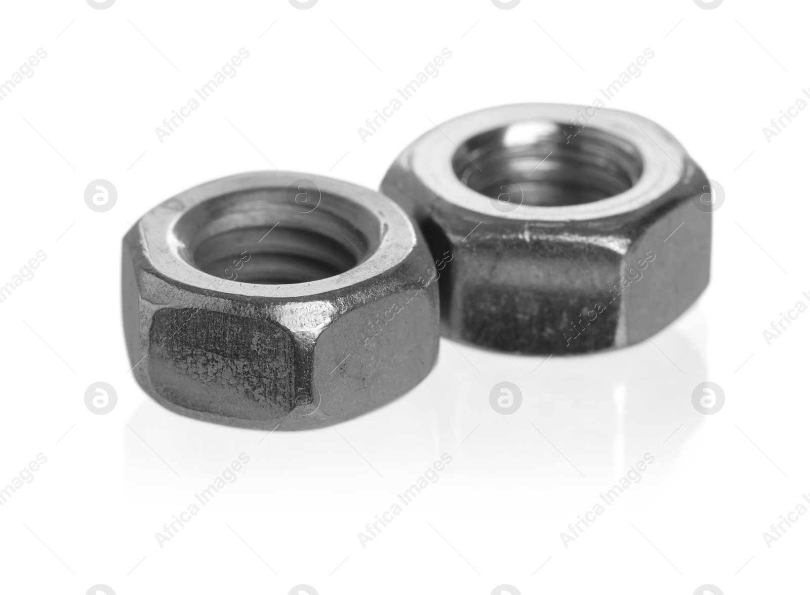 Photo of Metal hex nuts on mirror surface isolated on white. Hardware tool