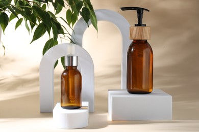 Photo of Promotion. Cosmetic products, podiums and green leaves on beige background