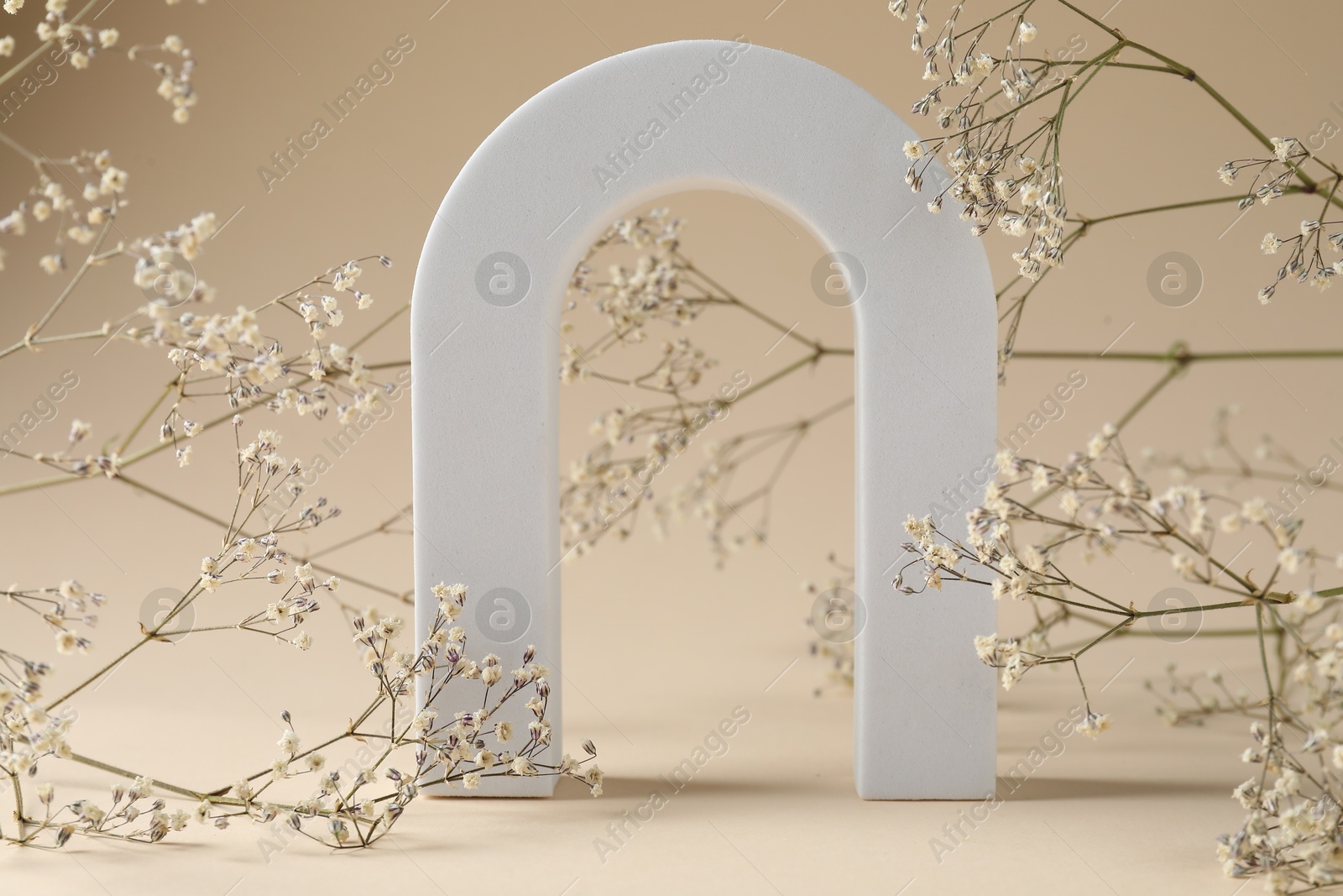 Promotion. White figure and gypsophila flowers on beige background, closeup Photo of Promotion. White figure and gypsophila flowers on beige background, closeup