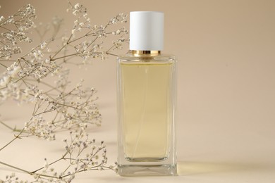 Photo of Promotion. Cosmetic product and gypsophila flowers on beige background, closeup
