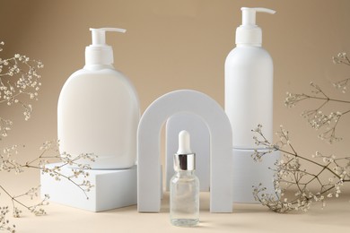 Photo of Promotion. Cosmetic products, podiums and gypsophila flowers on beige background