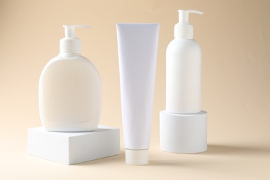 Photo of Promotion. Cosmetic products and podiums on beige background