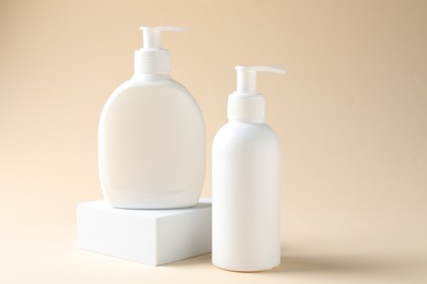 Photo of Promotion. Cosmetic products and podium on beige background