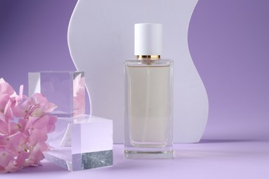 Photo of Promotion. Bottle of perfume, glass podium and hydrangea flowers on violet background