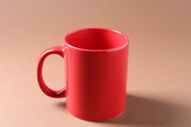 Photo of Promotion. Red mug on brown background, closeup