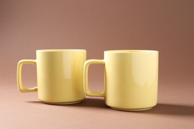 Photo of Promotion. Two yellow mugs on brown background