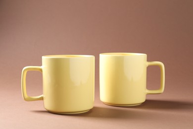 Photo of Promotion. Two yellow mugs on brown background