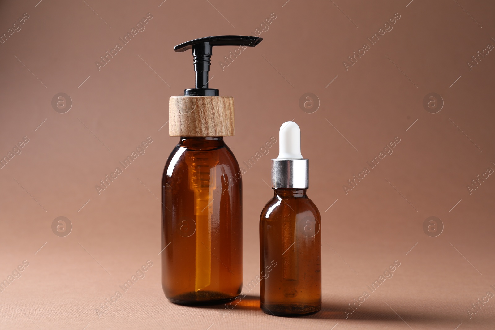 Promotion. Bottles of cosmetic products on brown background, closeup Photo of Promotion. Bottles of cosmetic products on brown background, closeup