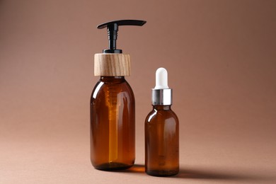 Photo of Promotion. Bottles of cosmetic products on brown background, closeup