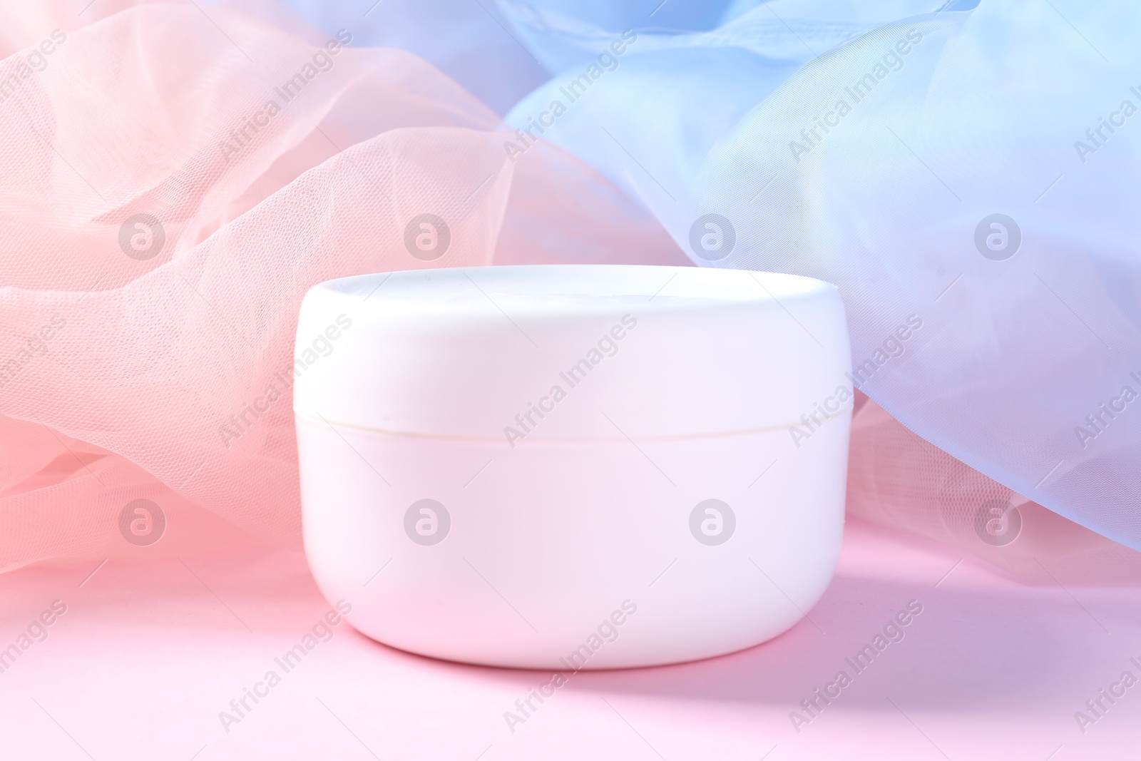 Promotion. Jar of cosmetic product and tulle cloth on pink background, closeup Photo of Promotion. Jar of cosmetic product and tulle cloth on pink background, closeup