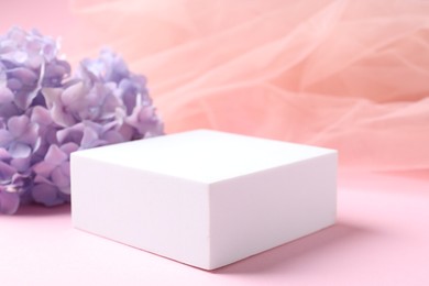 Photo of Promotion. Podium for product presentation, hydrangea flowers and tulle cloth on pink background, closeup