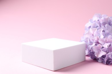Photo of Promotion. Podium for product presentation and hydrangea flowers on pink background, closeup