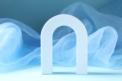Photo of Promotion. White figure and tulle cloth on light blue background