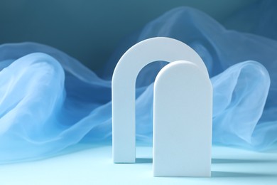Photo of Promotion. White figures and tulle cloth on light blue background