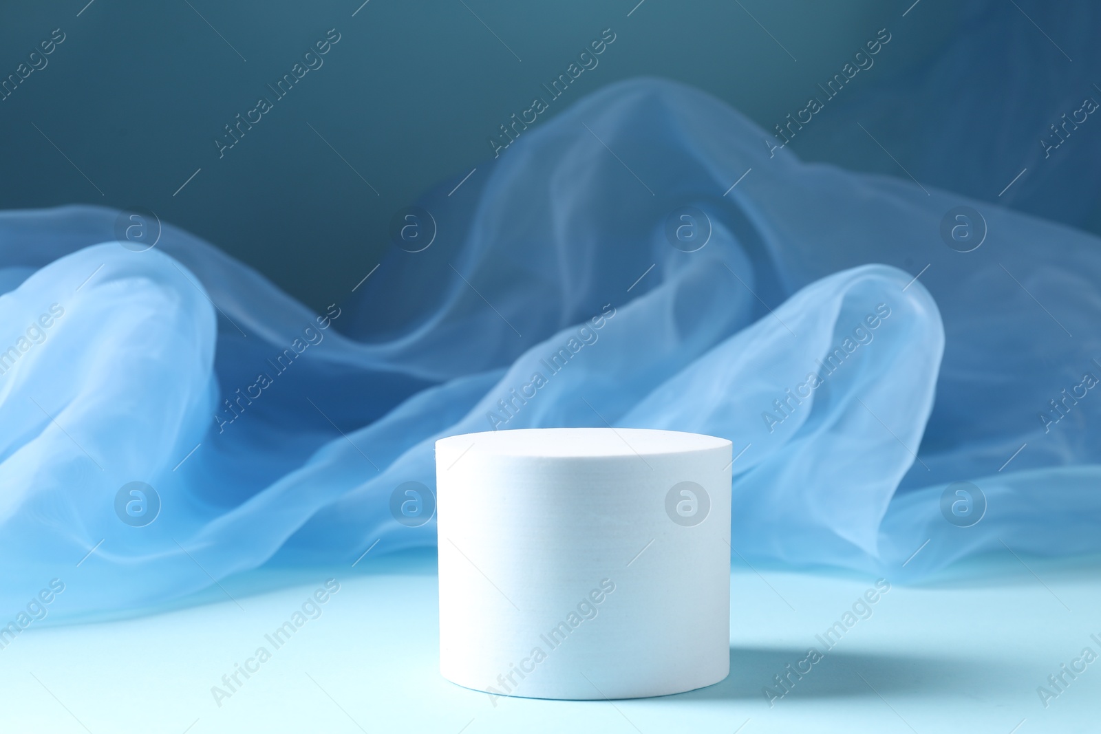 Promotion. Podium for product presentation and tulle cloth on light blue background Photo of Promotion. Podium for product presentation and tulle cloth on light blue background
