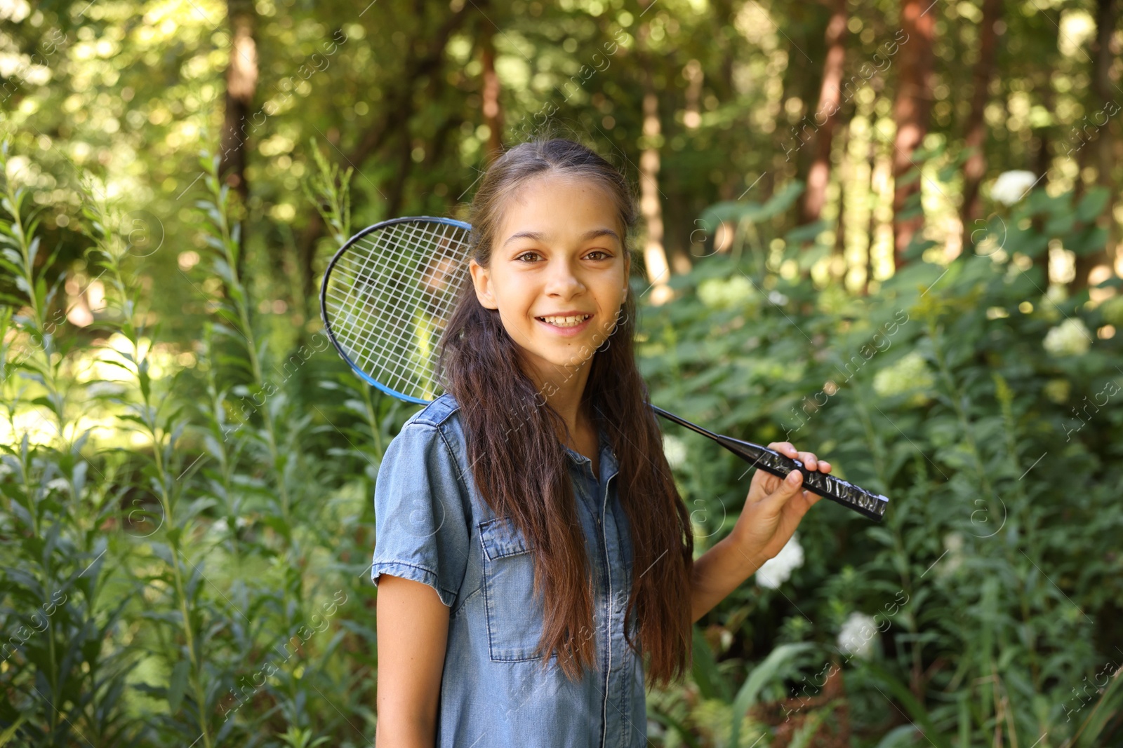 Portrait of smiling little girl with badminton racket in park Photo of Portrait of smiling little girl with badminton racket in park