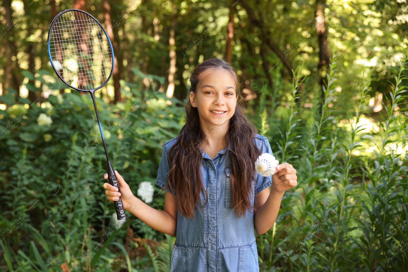 Portrait of smiling little girl with badminton racket and shuttlecock in park Photo of Portrait of smiling little girl with badminton racket and shuttlecock in park
