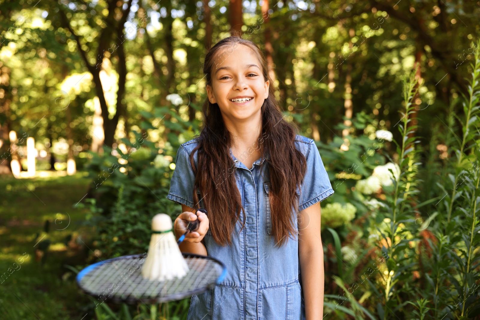 Portrait of smiling little girl with badminton racket and shuttlecock in park Photo of Portrait of smiling little girl with badminton racket and shuttlecock in park