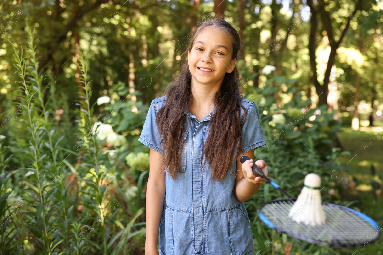 Portrait of smiling little girl with badminton racket and shuttlecock in park Photo of Portrait of smiling little girl with badminton racket and shuttlecock in park