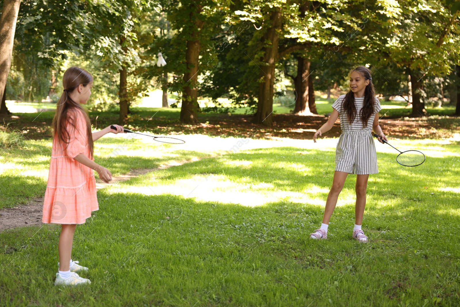 Cute little girls playing badminton in park Photo of Cute little girls playing badminton in park